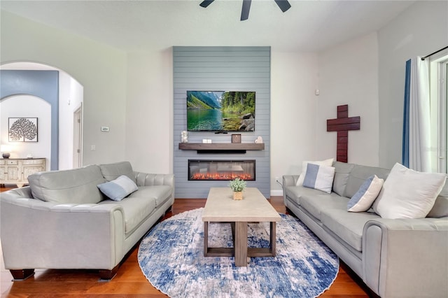 3380 Pawleys Loop N, Saint Cloud, FL 34769 - living room with ceiling fan, wood finished floors, a large fireplace, and arched walkways