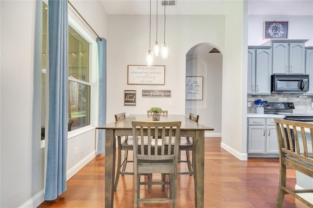 3380 Pawleys Loop N, Saint Cloud, FL 34769 - dining space featuring arched walkways, wood finished floors, and baseboards