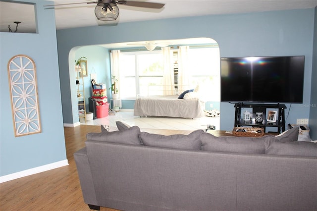 1364 Gainesville Dr, Deltona, FL 32725 - living area featuring arched walkways, ceiling fan, wood finished floors, and baseboards