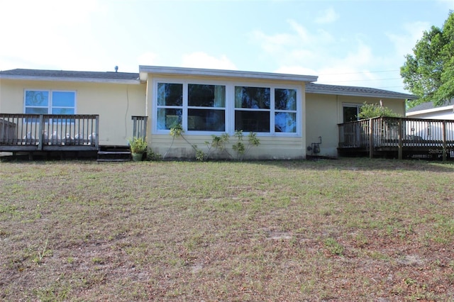 1364 Gainesville Dr, Deltona, FL 32725 - back of property featuring a deck, a yard, and stucco siding