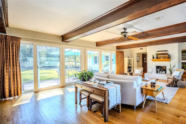 2001 Lily Ct, Sanford, FL 32771 - living room featuring light wood-type flooring, beamed ceiling, a fireplace, and ceiling fan