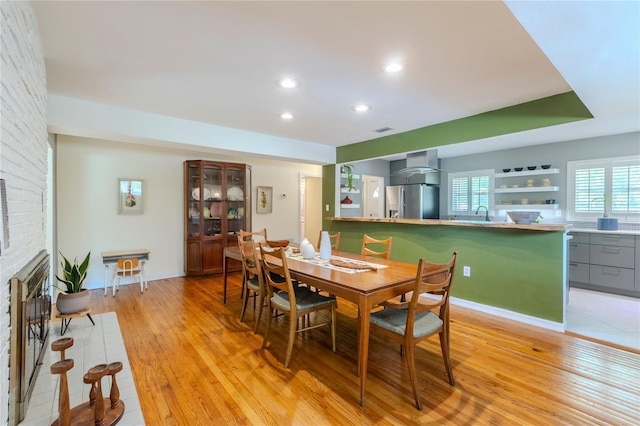 2001 Lily Ct, Sanford, FL 32771 - dining area featuring light wood-style floors, a brick fireplace, and recessed lighting