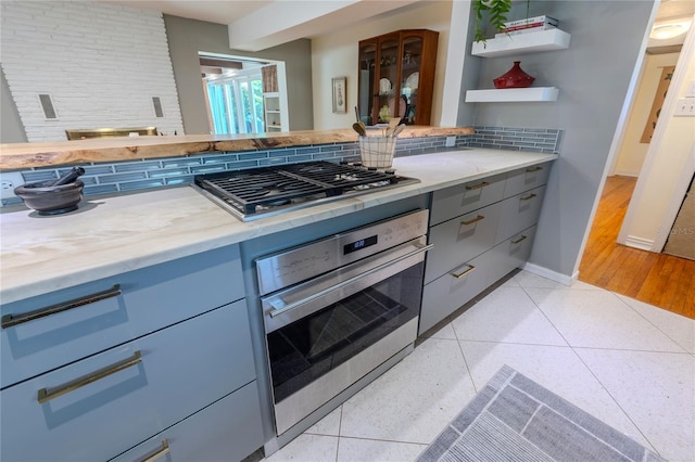 2001 Lily Ct, Sanford, FL 32771 - kitchen with appliances with stainless steel finishes, decorative backsplash, gray cabinetry, and light stone counters