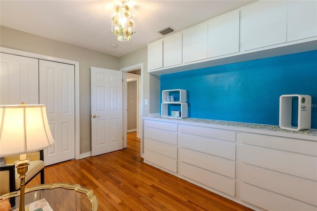 2001 Lily Ct, Sanford, FL 32771 - unfurnished bedroom with light wood-style flooring, a chandelier, baseboards, and a closet