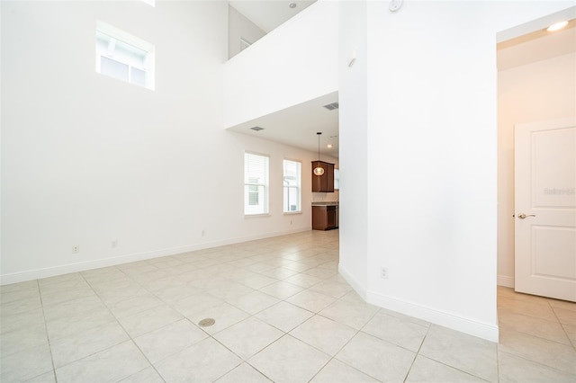 6132 Bimini Twist Loop, Orlando, FL 32819 - unfurnished living room featuring light tile patterned flooring, a towering ceiling, and baseboards