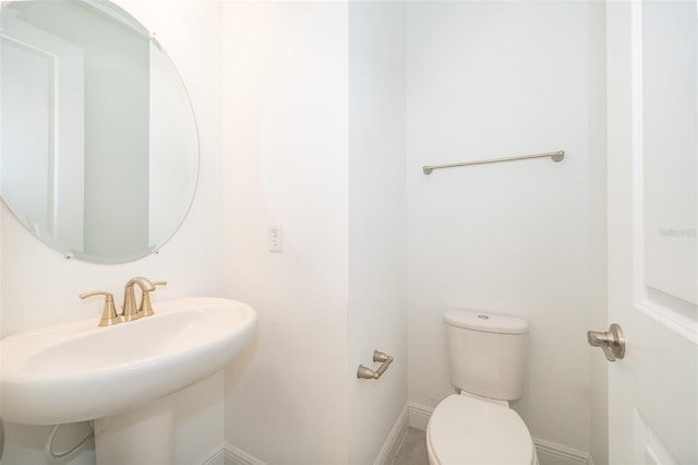 6132 Bimini Twist Loop, Orlando, FL 32819 - bathroom featuring toilet, baseboards, and a sink