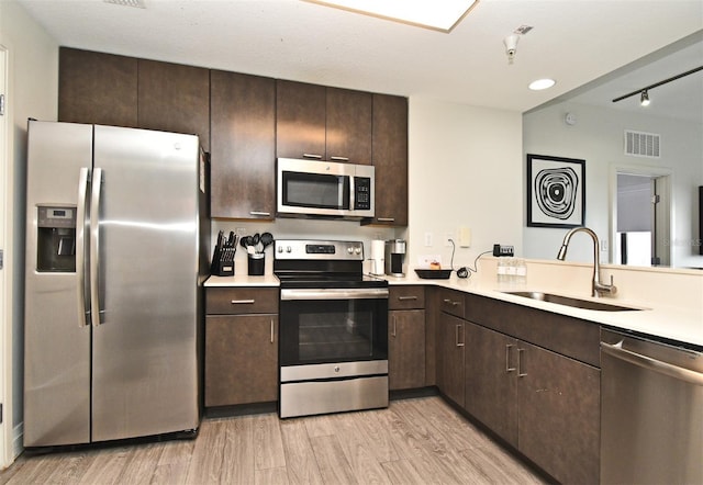 14501 Grove Resort Ave Unit 3741, Winter Garden, FL 34787 - kitchen featuring stainless steel appliances, a sink, dark brown cabinetry, and light countertops