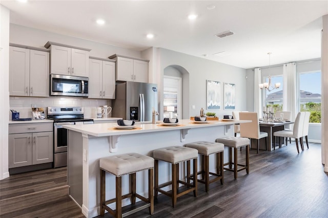 1974 Walnut Creek Dr, Kissimmee, FL 34744 - kitchen with appliances with stainless steel finishes, dark wood-style floors, backsplash, gray cabinetry, and light countertops