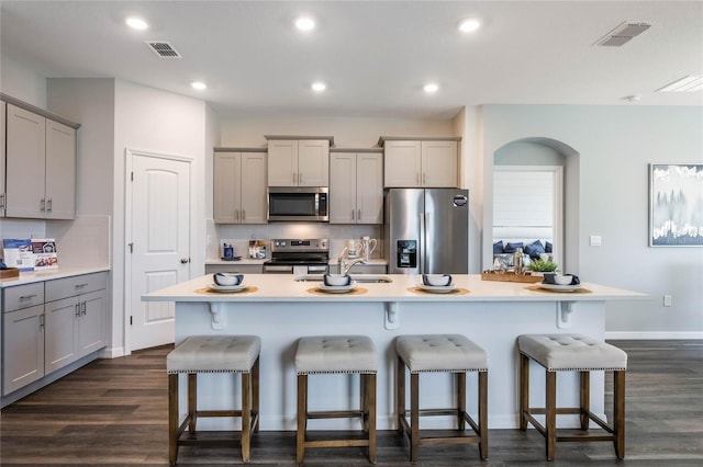 1974 Walnut Creek Dr, Kissimmee, FL 34744 - kitchen featuring appliances with stainless steel finishes, gray cabinetry, a kitchen bar, and recessed lighting
