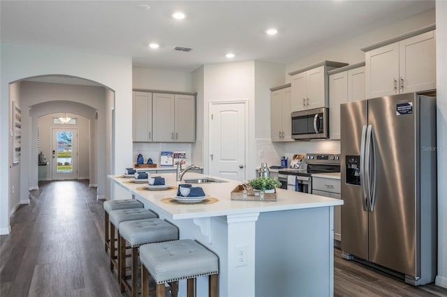 1974 Walnut Creek Dr, Kissimmee, FL 34744 - kitchen with appliances with stainless steel finishes, a sink, a kitchen bar, a kitchen island with sink, and tasteful backsplash