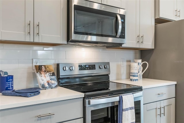 1974 Walnut Creek Dr, Kissimmee, FL 34744 - kitchen with appliances with stainless steel finishes, light countertops, tasteful backsplash, and gray cabinetry