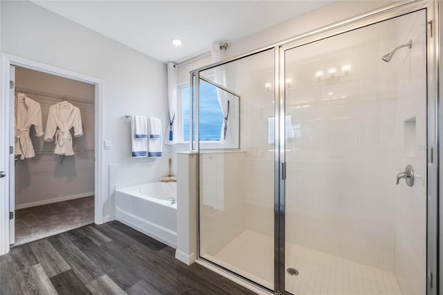 1974 Walnut Creek Dr, Kissimmee, FL 34744 - bathroom featuring wood finished floors, a garden tub, a stall shower, and a spacious closet