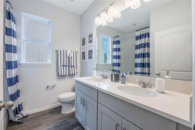 1974 Walnut Creek Dr, Kissimmee, FL 34744 - full bath with toilet, wood finished floors, double vanity, baseboards, and a shower with shower curtain