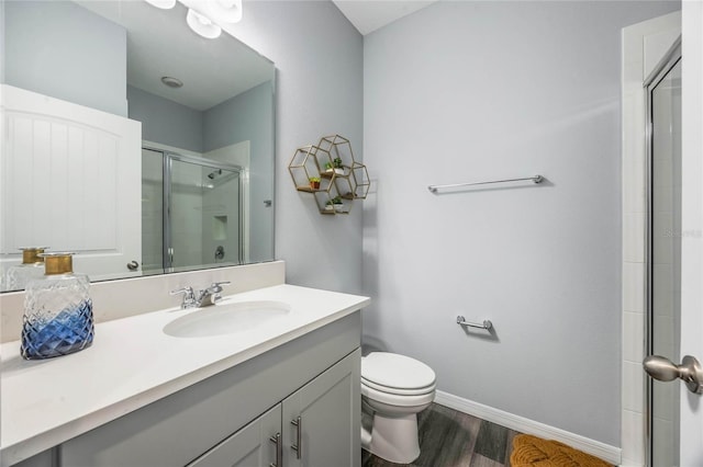 1974 Walnut Creek Dr, Kissimmee, FL 34744 - bathroom featuring a shower stall, wood finished floors, toilet, vanity, and baseboards