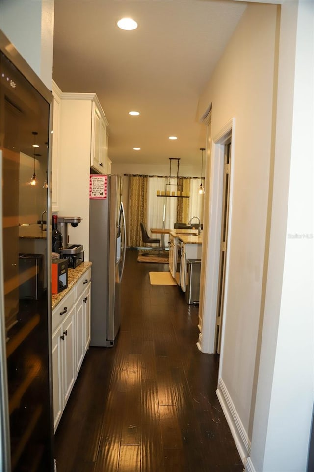 hall with dark wood finished floors and recessed lighting