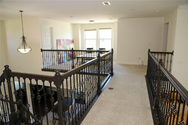 hallway with an upstairs landing and baseboards