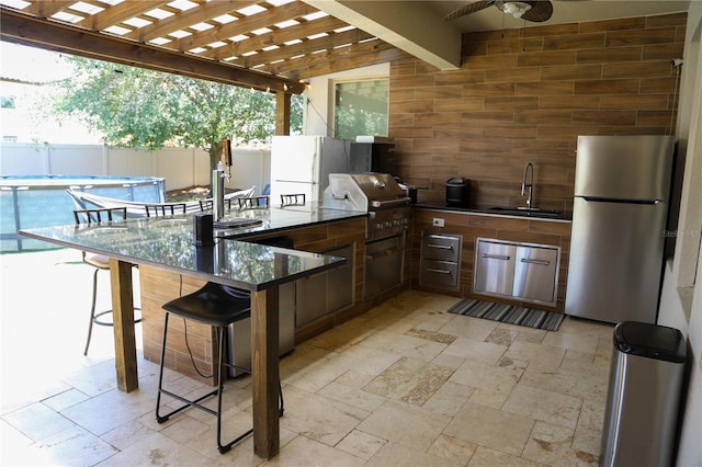 view of patio featuring a sink, fence, area for grilling, and ceiling fan