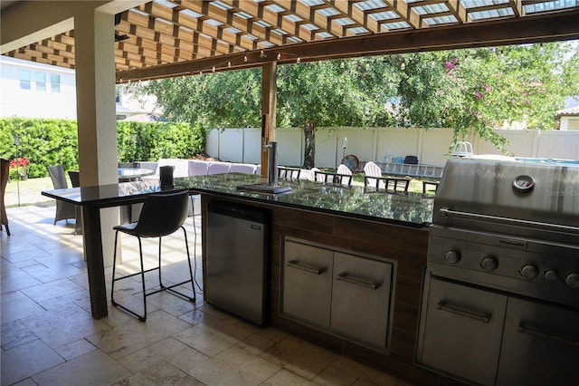 view of patio / terrace featuring fence, area for grilling, a pergola, and a bar