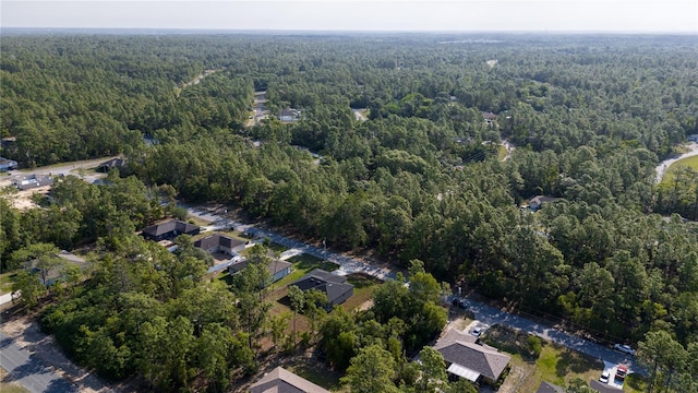 view of property location with a forest
