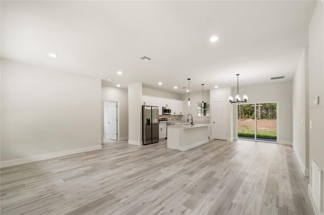 unfurnished living room featuring a chandelier, a sink, recessed lighting, light wood-type flooring, and baseboards