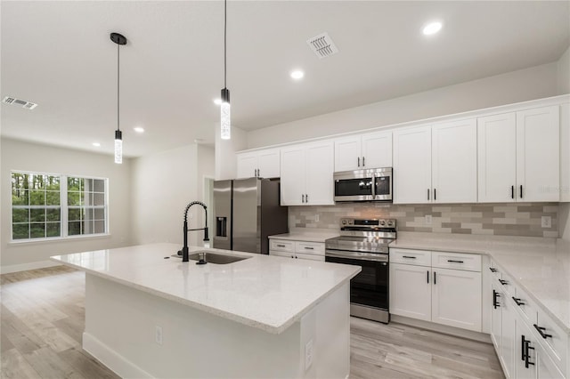 kitchen with stainless steel appliances, a sink, light wood-style flooring, backsplash, and recessed lighting