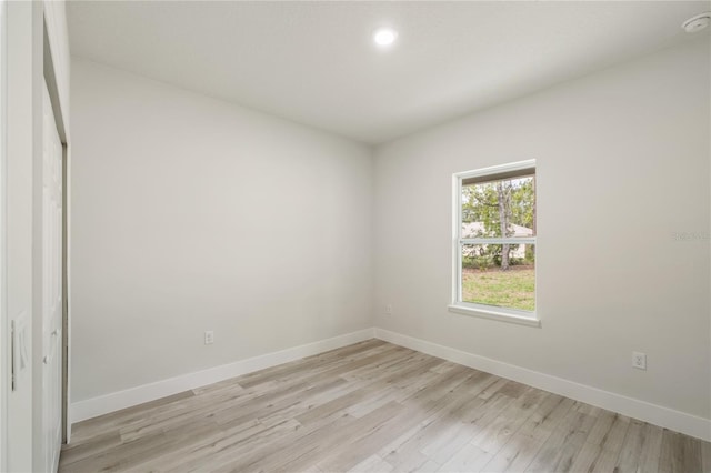 unfurnished room featuring baseboards, light wood-style flooring, and recessed lighting
