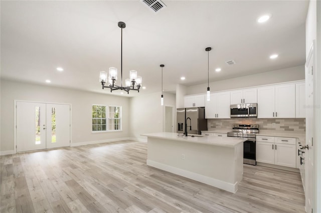 kitchen featuring stainless steel appliances, backsplash, a chandelier, white cabinetry, and recessed lighting