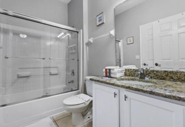 3193 Yellow Lantana Ln, Kissimmee, FL 34747 - bathroom featuring tile patterned flooring, toilet, vanity, and combined bath / shower with glass door