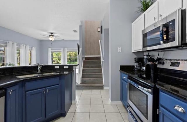 3193 Yellow Lantana Ln, Kissimmee, FL 34747 - kitchen featuring stainless steel appliances, blue cabinetry, a sink, and dark countertops
