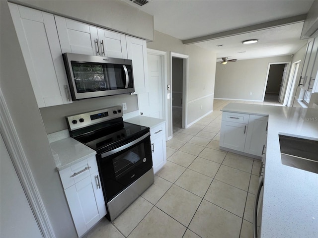 6624 Kristin Ct, Orlando, FL 32818 - kitchen featuring appliances with stainless steel finishes, ceiling fan, white cabinetry, light tile patterned floors, and baseboards