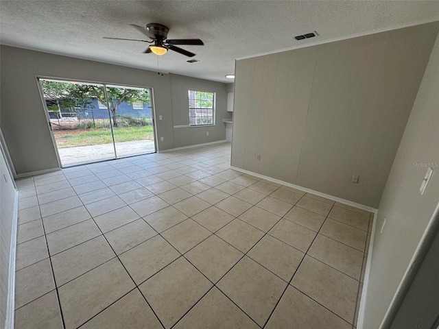 6624 Kristin Ct, Orlando, FL 32818 - spare room with a textured ceiling, light tile patterned flooring, baseboards, a ceiling fan, and wood walls