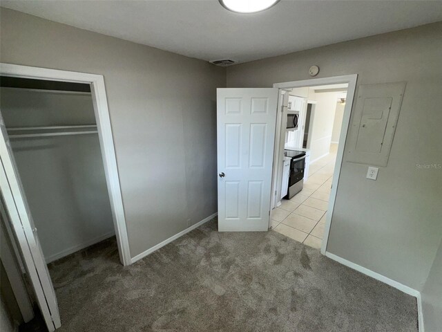6624 Kristin Ct, Orlando, FL 32818 - unfurnished bedroom featuring light colored carpet, a closet, light tile patterned floors, and baseboards