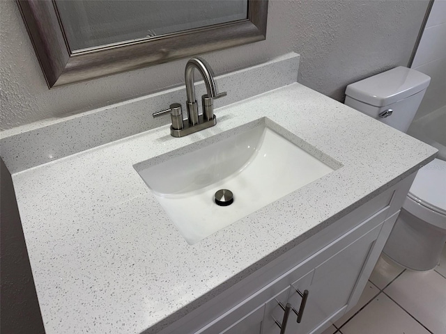 6624 Kristin Ct, Orlando, FL 32818 - bathroom featuring vanity, toilet, a textured wall, and tile patterned flooring