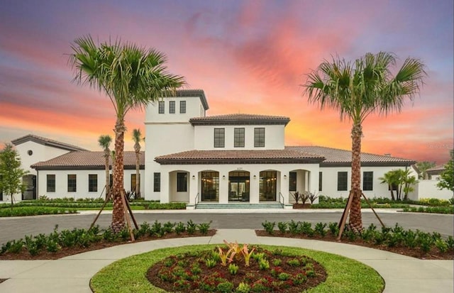 2030 Majorca Dr, Kissimmee, FL 34747 - back of house with a tiled roof, stucco siding, covered porch, and curved driveway