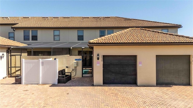 2030 Majorca Dr, Kissimmee, FL 34747 - back of house with stucco siding, a tiled roof, an attached garage, and decorative driveway