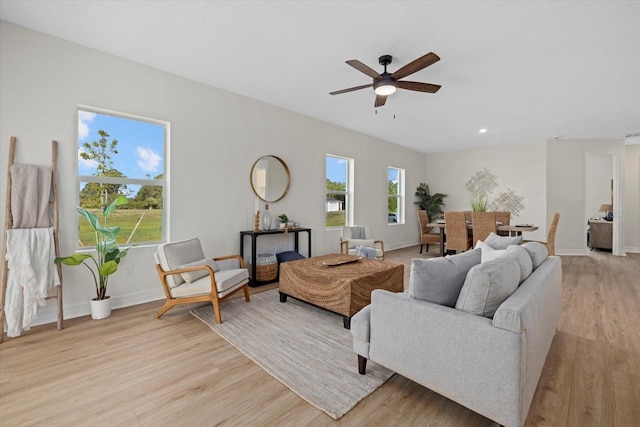 living room with light wood-style floors, ceiling fan, baseboards, and recessed lighting