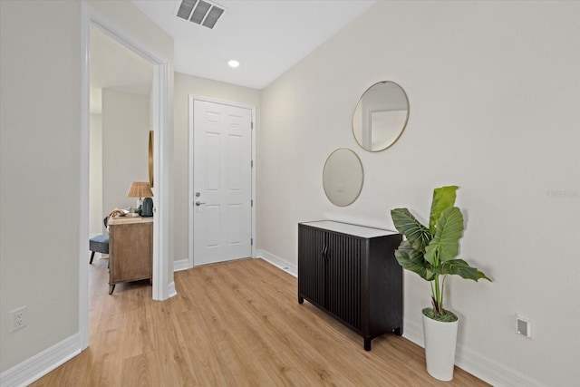 hallway featuring baseboards and light wood finished floors