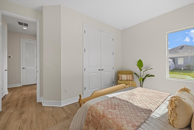 bedroom featuring baseboards, wood finished floors, and a closet