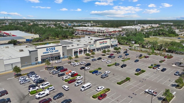 drone / aerial view of a commercial area and a tree filled landscape
