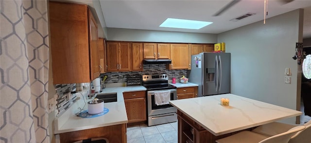 1302 Center St, Ocoee, FL 34761 - kitchen featuring stainless steel appliances, ventilation hood, a skylight, and brown cabinetry