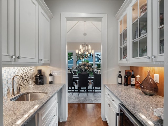 9916 Lone Tree Ln, Orlando, FL 32836 - kitchen featuring a sink, decorative backsplash, dark wood-style flooring, white cabinets, and a chandelier