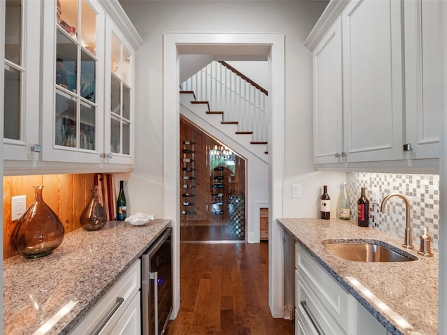 9916 Lone Tree Ln, Orlando, FL 32836 - kitchen featuring beverage cooler, a sink, dark wood-type flooring, tasteful backsplash, and light stone counters
