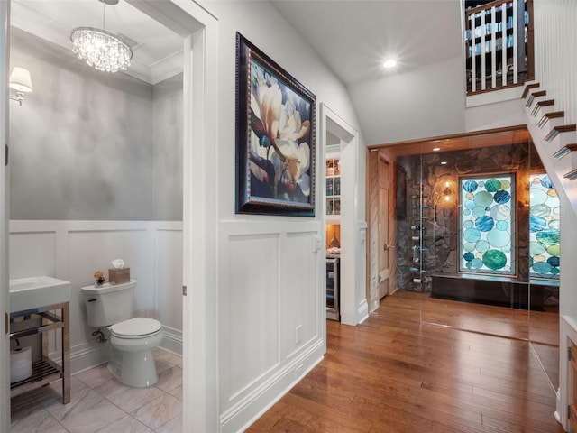 9916 Lone Tree Ln, Orlando, FL 32836 - bathroom with a decorative wall, toilet, a chandelier, wood finished floors, and a wainscoted wall