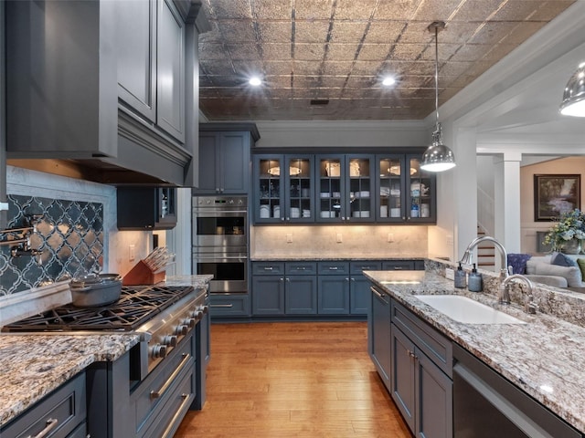 9916 Lone Tree Ln, Orlando, FL 32836 - kitchen with a sink, appliances with stainless steel finishes, light wood-style floors, ornamental molding, and tasteful backsplash