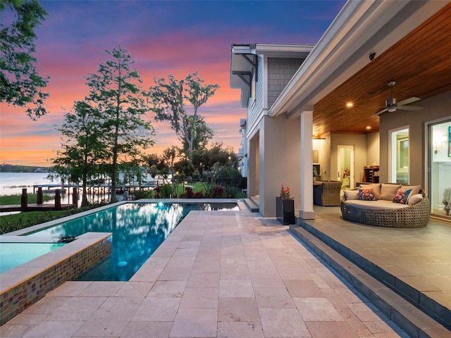 9916 Lone Tree Ln, Orlando, FL 32836 - pool at dusk with a patio, a water view, ceiling fan, and an outdoor living space
