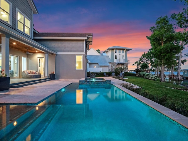 9916 Lone Tree Ln, Orlando, FL 32836 - pool at dusk featuring a patio area, a ceiling fan, a pool with connected hot tub, and a yard