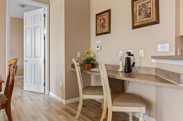 dining area featuring light wood finished floors and baseboards
