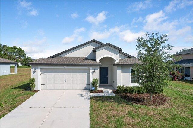 1119 Union Ave, Mascotte, FL 34753 - single story home featuring stucco siding, a shingled roof, a garage, driveway, and a front yard
