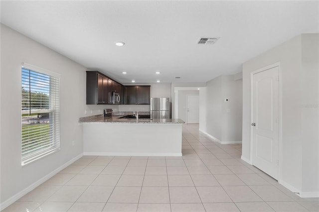 1119 Union Ave, Mascotte, FL 34753 - kitchen featuring appliances with stainless steel finishes, dark brown cabinetry, baseboards, a peninsula, and recessed lighting