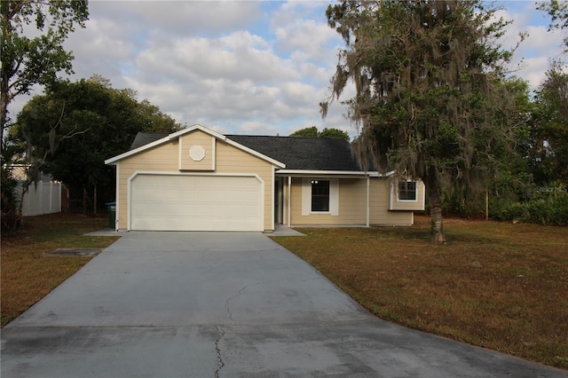 single story home featuring concrete driveway, a front yard, and an attached garage